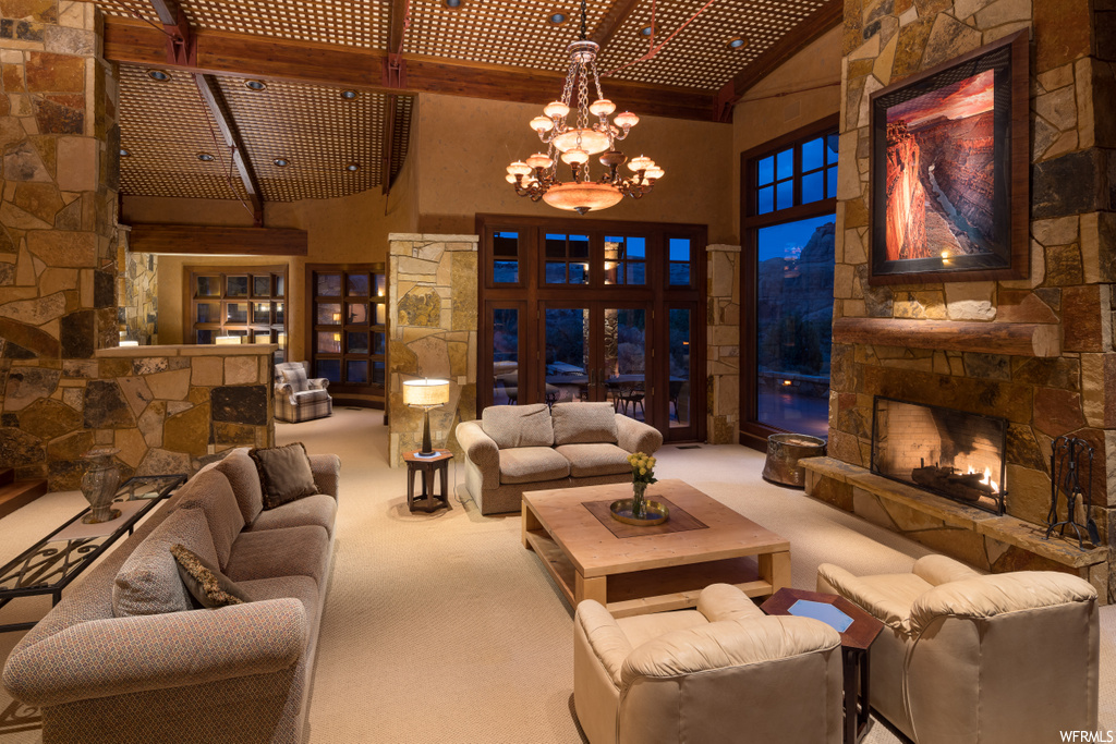 carpeted living room featuring a chandelier, wood beam ceiling, and a fireplace