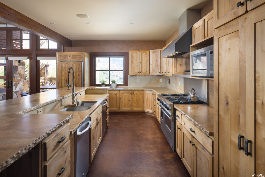 kitchen featuring natural light, dishwasher, microwave, gas range oven, dark floors, and kitchen island sink