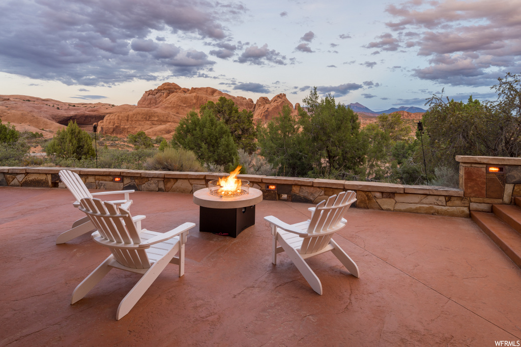 view of patio with a mountain view and fire pit