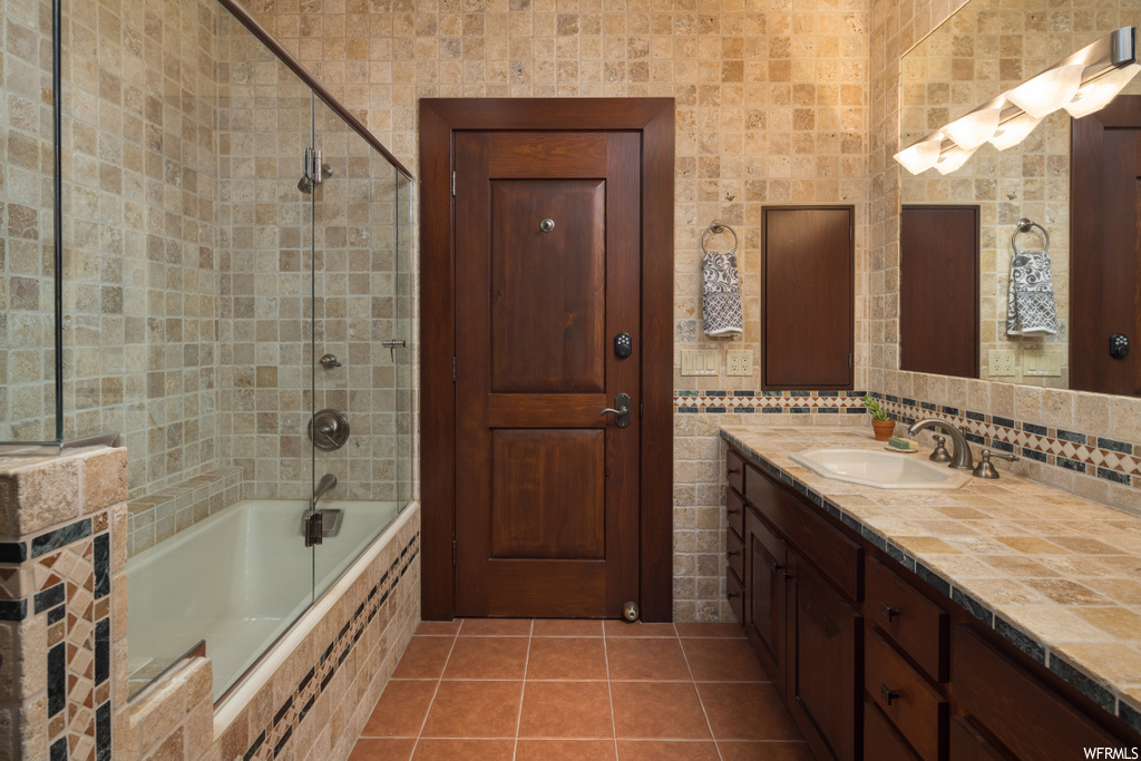 bathroom featuring tile flooring, vanity, bath / shower combo with glass door, and mirror