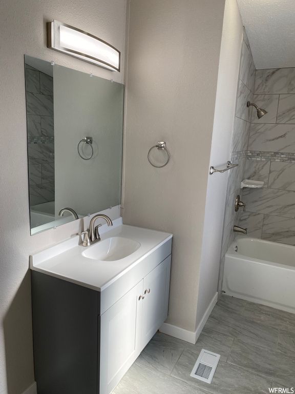bathroom featuring tile flooring, bath / shower combination, vanity, and mirror