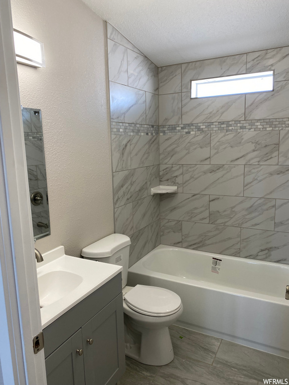 full bathroom featuring toilet, washtub / shower combination, mirror, and vanity with extensive cabinet space
