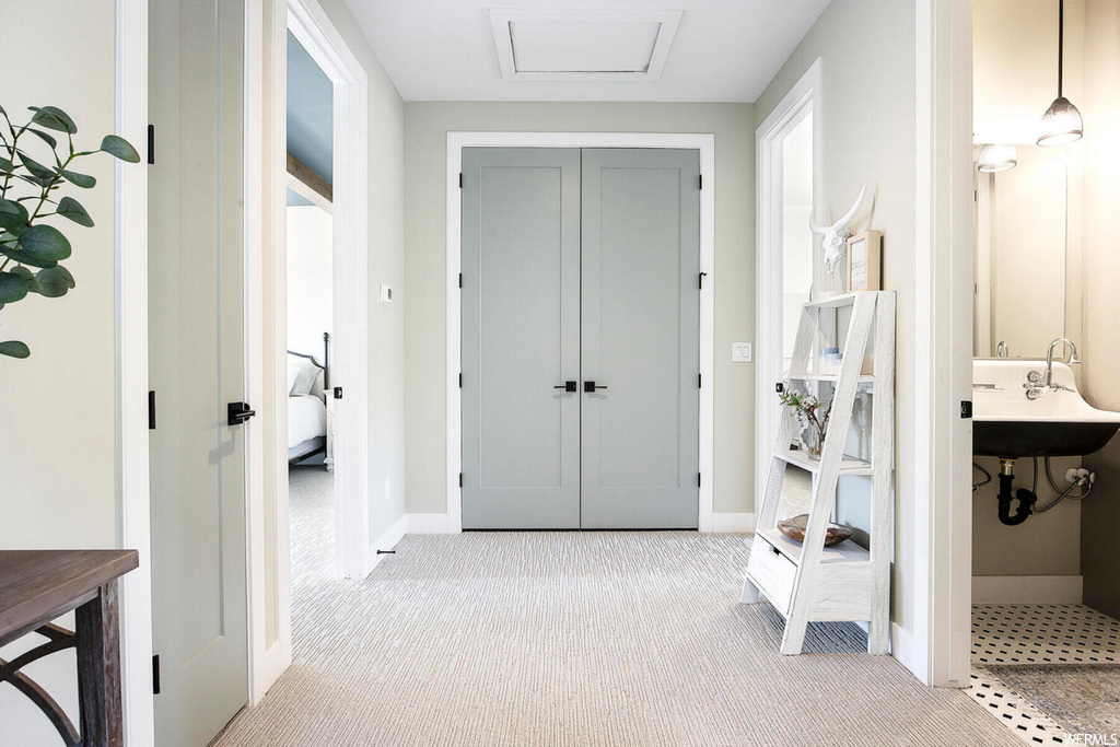 Corridor with light colored carpet and sink
