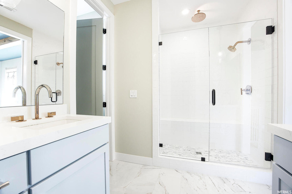 Bathroom featuring tile flooring, large vanity, and walk in shower