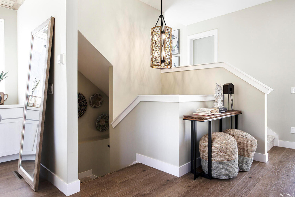 Stairway featuring an inviting chandelier and hardwood / wood-style flooring