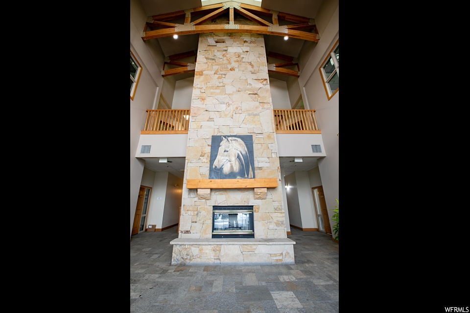 interior space featuring an outdoor fireplace and wood beam ceiling