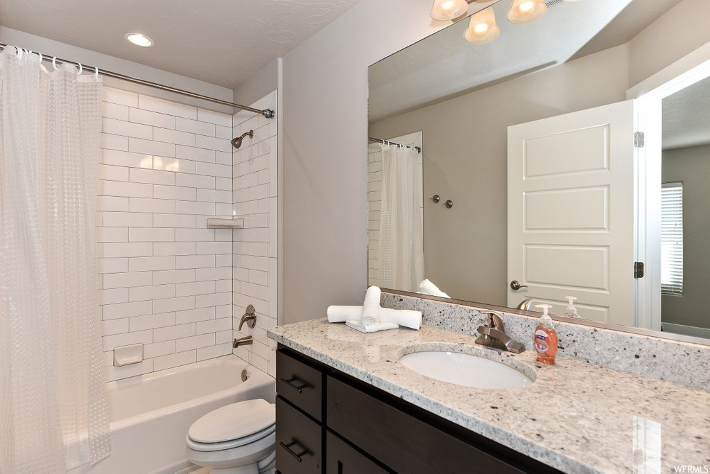 full bathroom with toilet, vanity, shower curtain, mirror, and washtub / shower combination