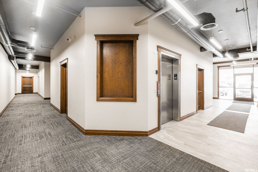 hallway with natural light and an elevator