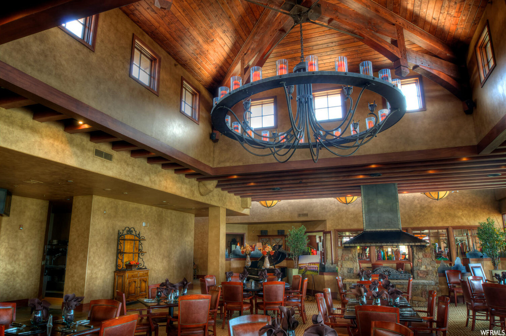 building lobby with a high ceiling, a chandelier, and wood beam ceiling