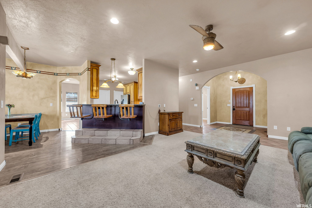 Hardwood floored living room with a breakfast bar area and natural light