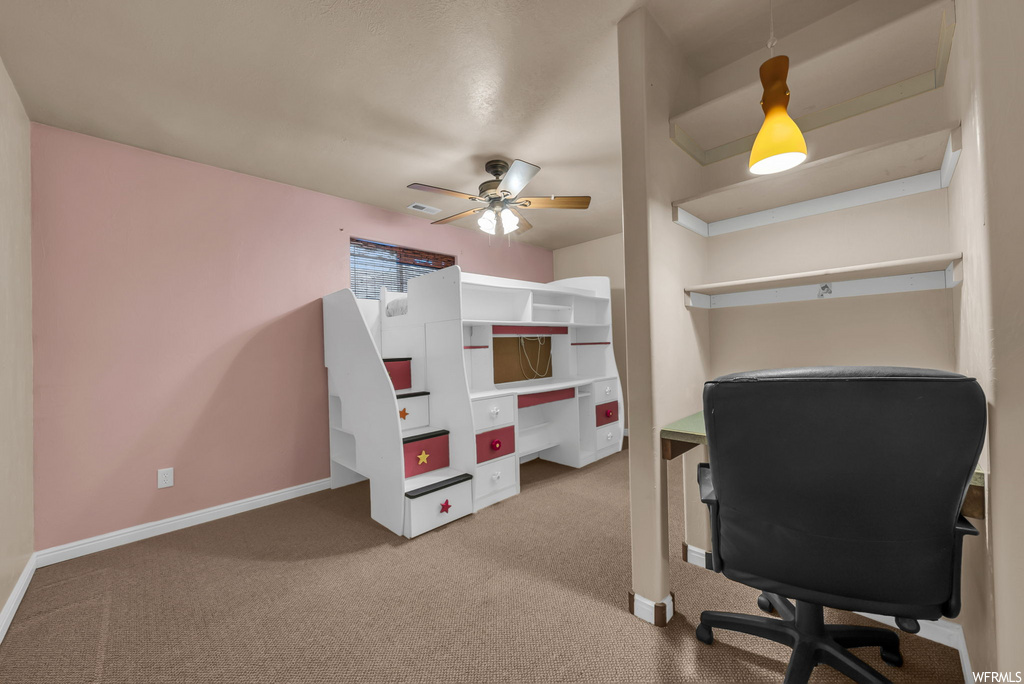 Carpeted office space with a ceiling fan