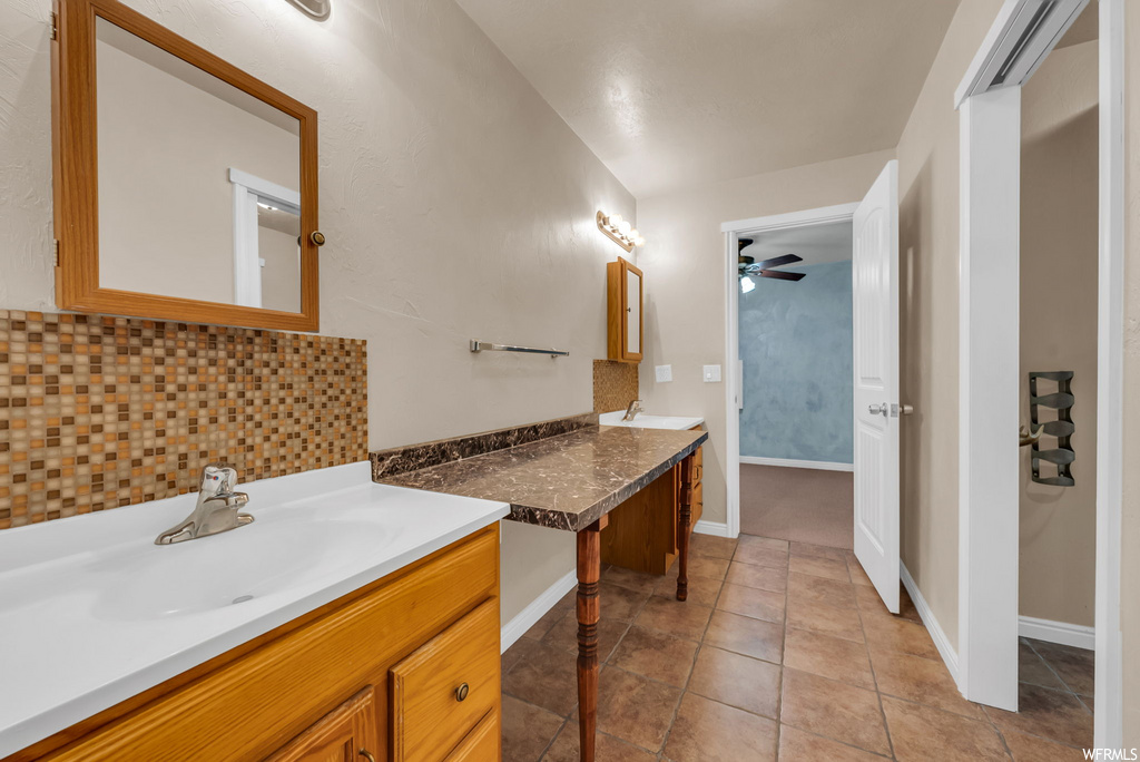 Bathroom featuring tile flooring, a ceiling fan, mirror, and dual bowl vanity