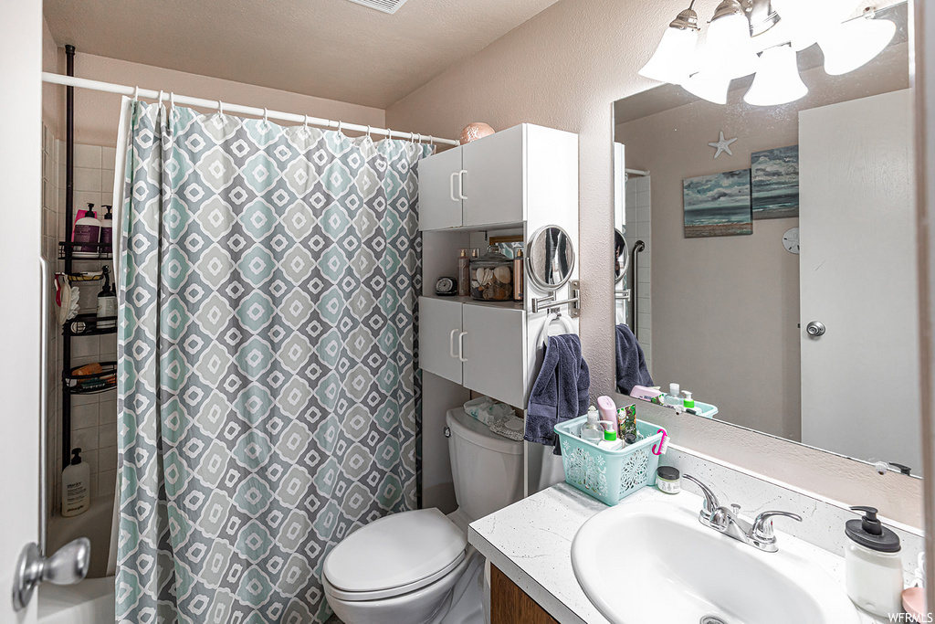 bathroom featuring shower curtain, mirror, toilet, and vanity