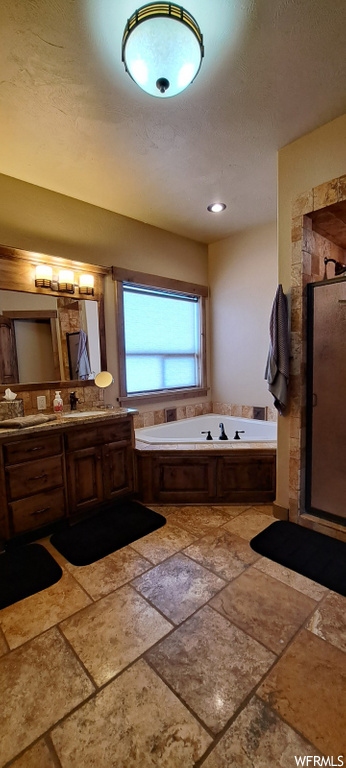 bathroom featuring natural light, tile flooring, shower with separate bathtub, mirror, and vanity