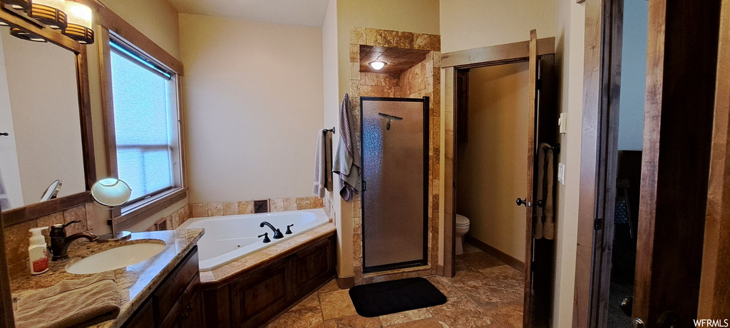 bathroom with natural light, tile flooring, shower with separate bathtub, and toilet