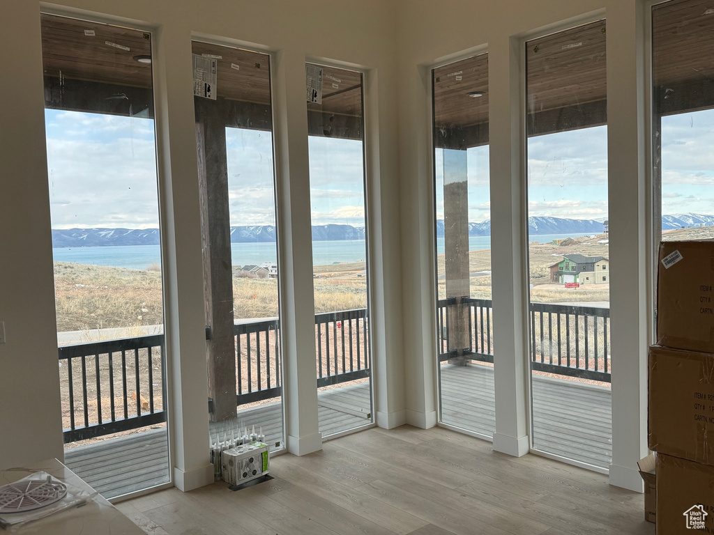 Unfurnished sunroom with a water and mountain view