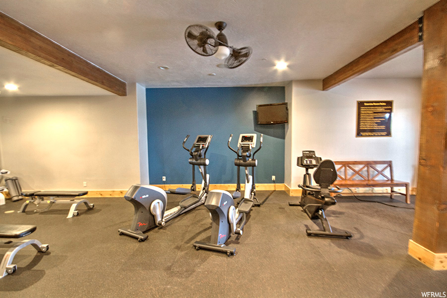 workout room with wood beam ceiling