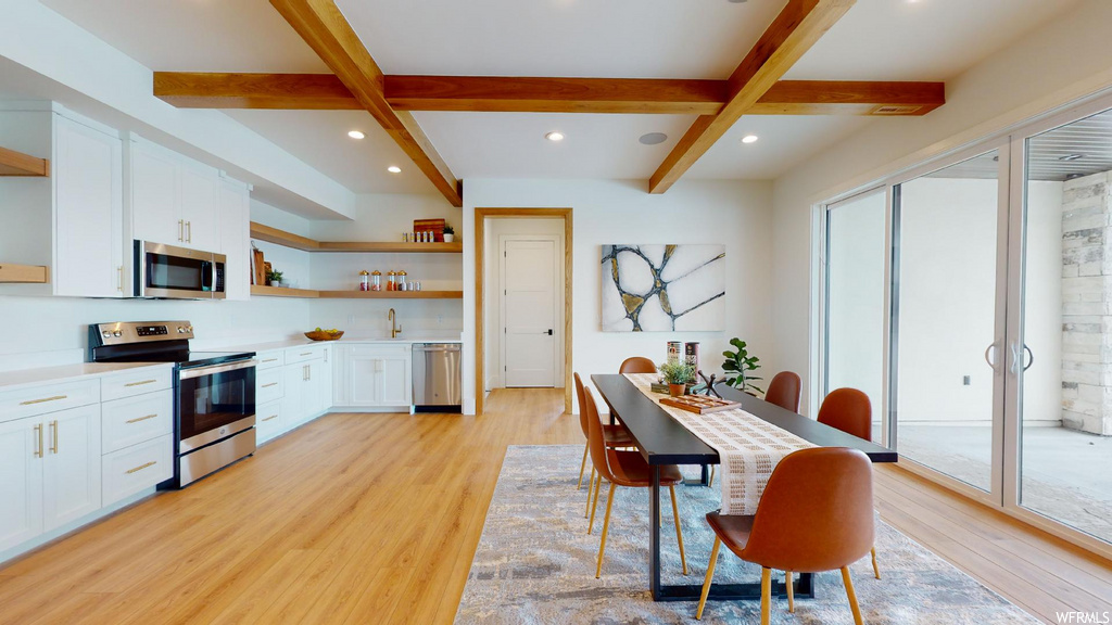 wood floored dining space with beamed ceiling and microwave