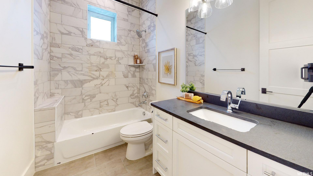 full bathroom with natural light, tile floors, vanity, shower / bathtub combination, toilet, and mirror