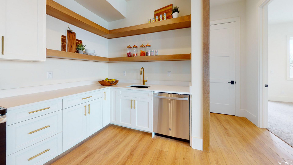 kitchen featuring dishwasher, light hardwood floors, and light countertops