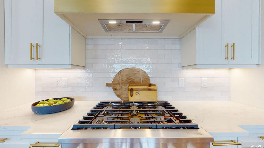 kitchen with ventilation hood, stainless steel finishes, and light floors