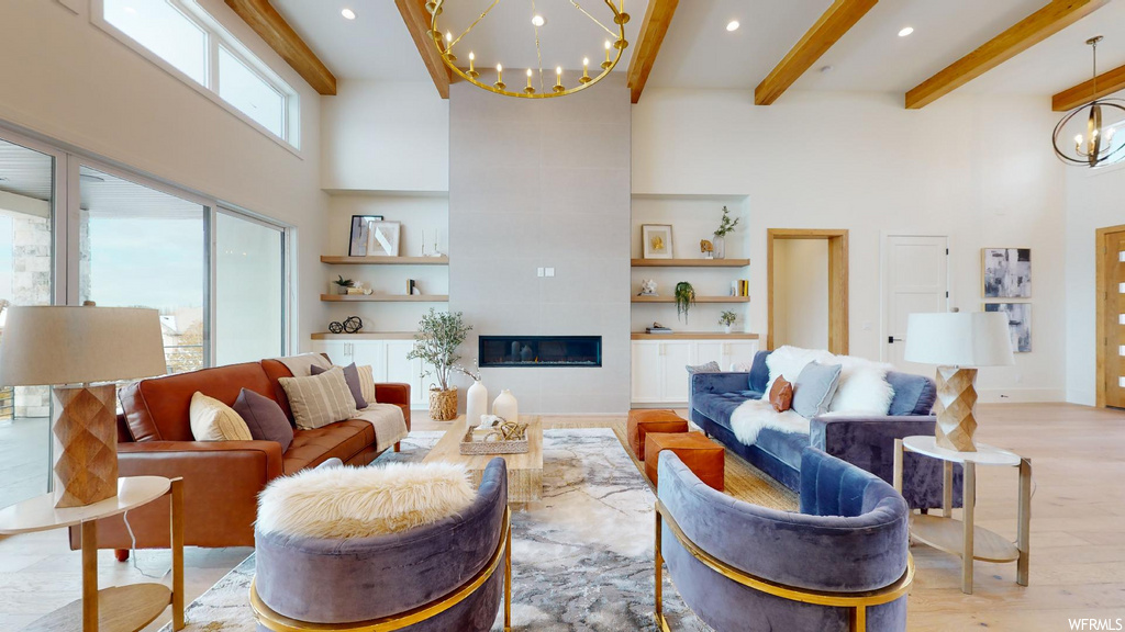 living room with natural light, a high ceiling, a notable chandelier, and beamed ceiling