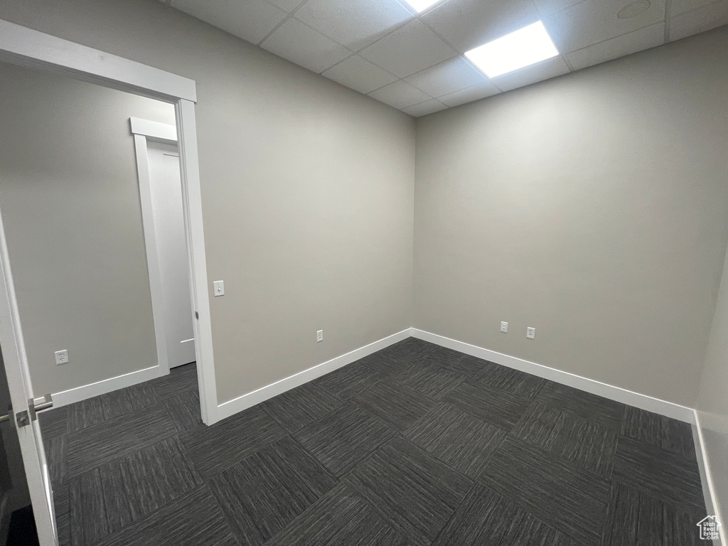 Carpeted spare room featuring a drop ceiling