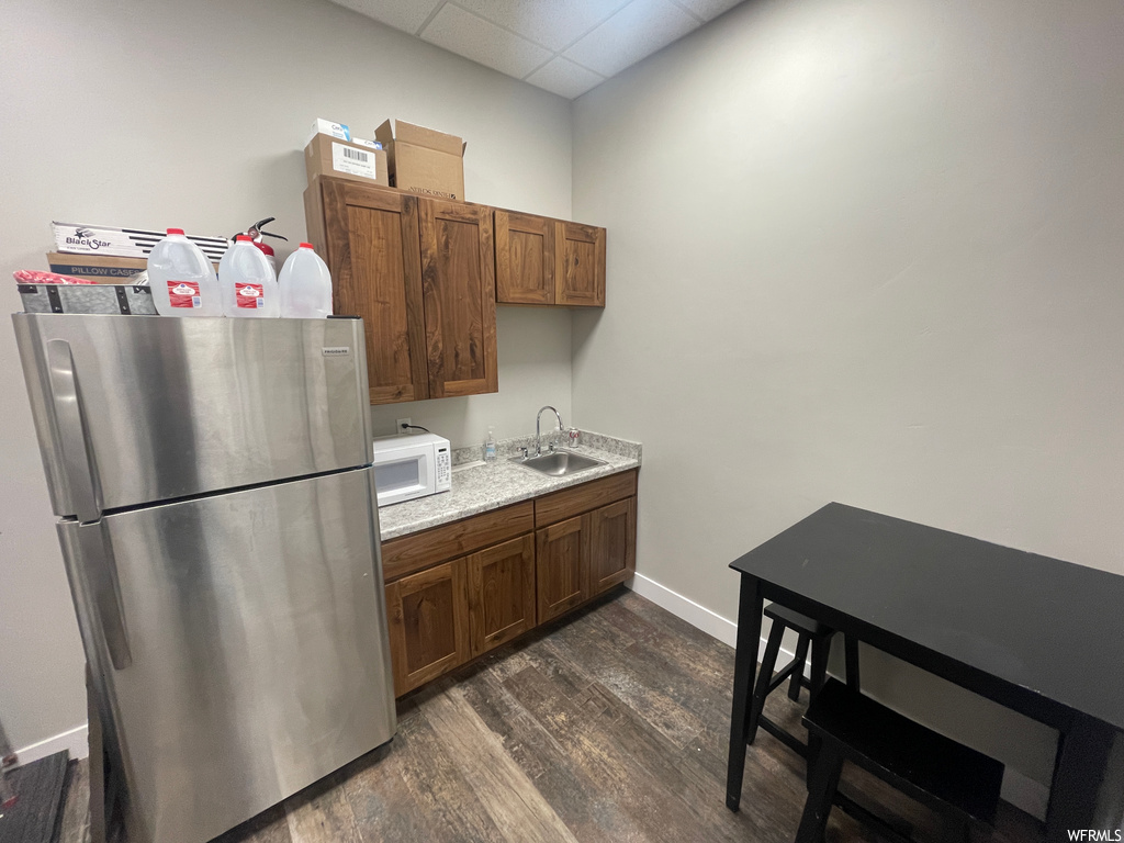 kitchen with refrigerator, microwave, and dark hardwood floors