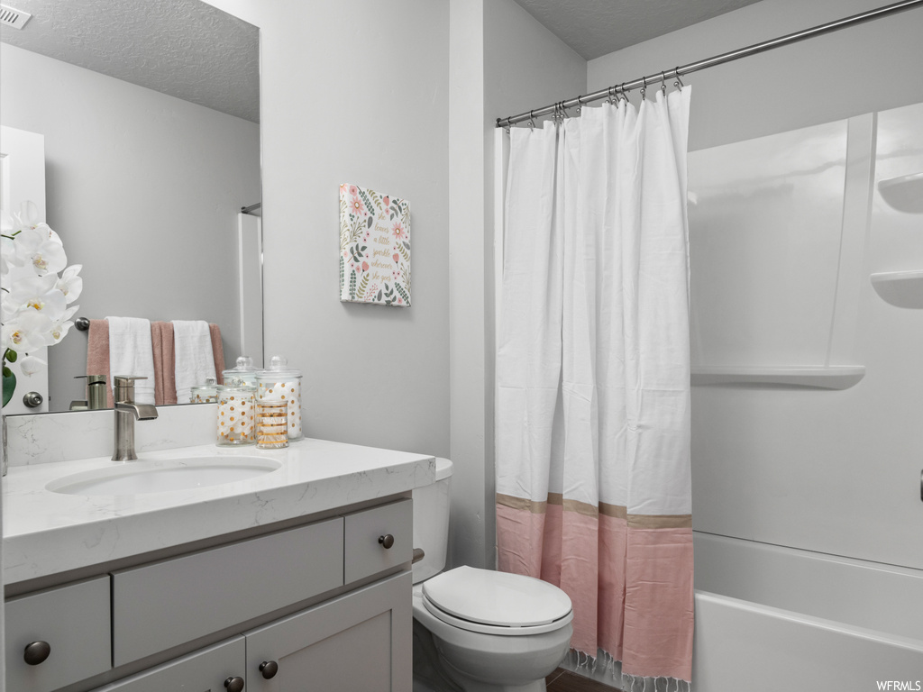 full bathroom with toilet, shower curtain, mirror, bathtub / shower combination, and vanity