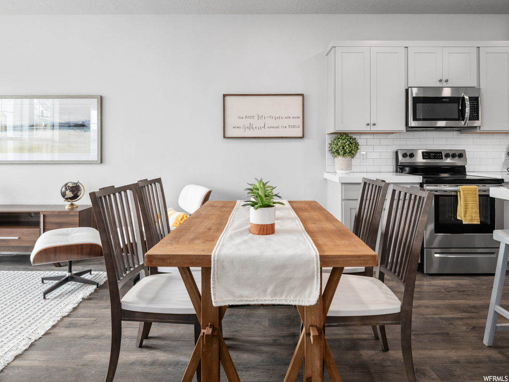 wood floored dining room featuring microwave