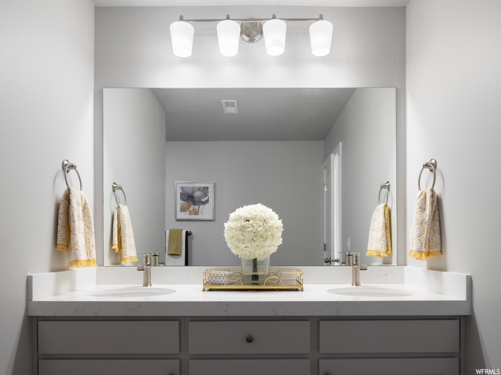 bathroom featuring multiple mirrors and double vanities