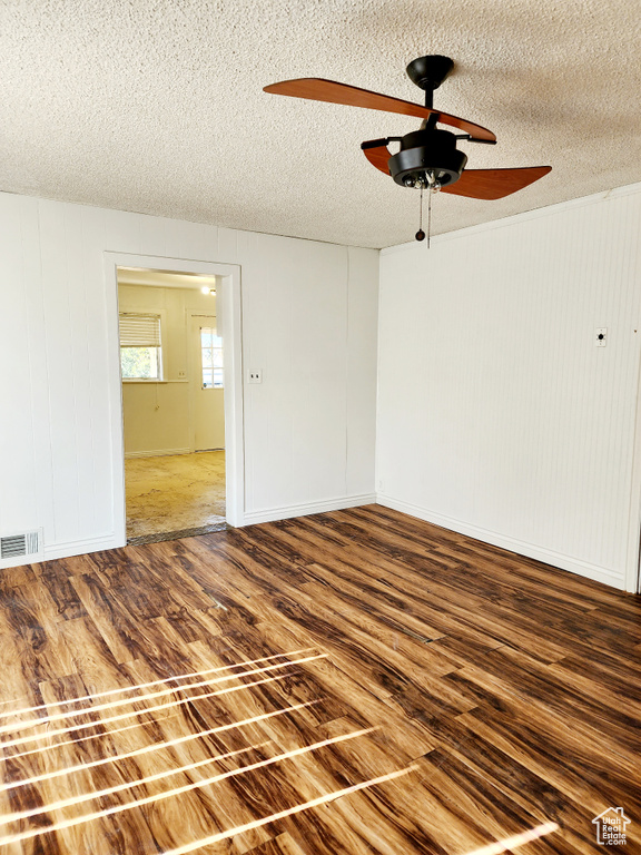 Unfurnished room with wood-type flooring, a textured ceiling, and ceiling fan