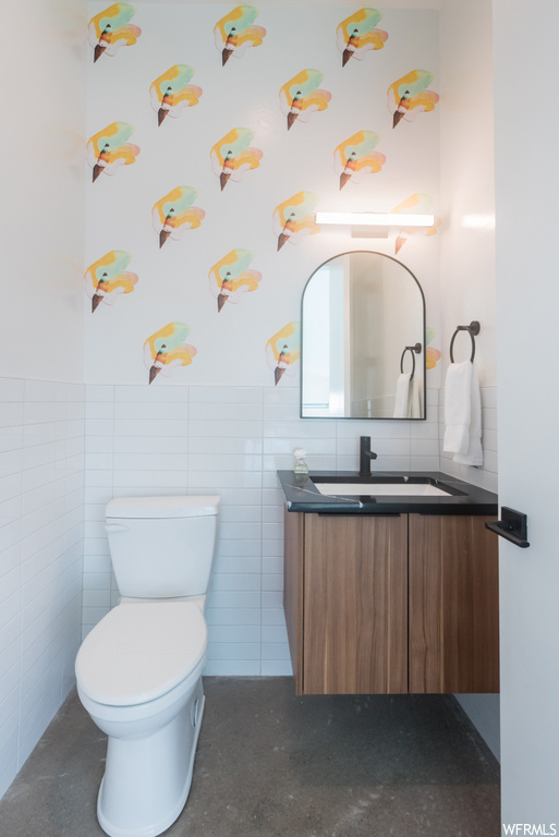 half bathroom featuring vanity, toilet, and mirror