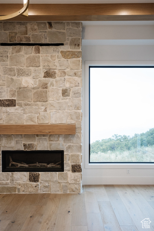 Interior details featuring a stone fireplace and light hardwood / wood-style floors