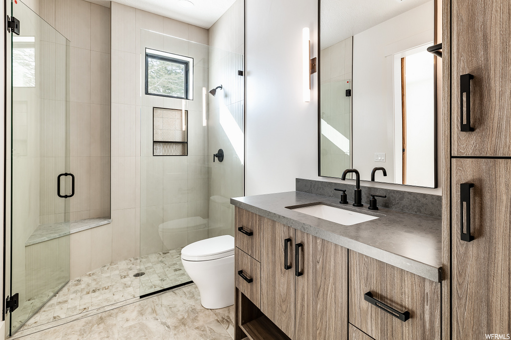 full bathroom featuring tile flooring, mirror, shower cabin, vanity, and toilet