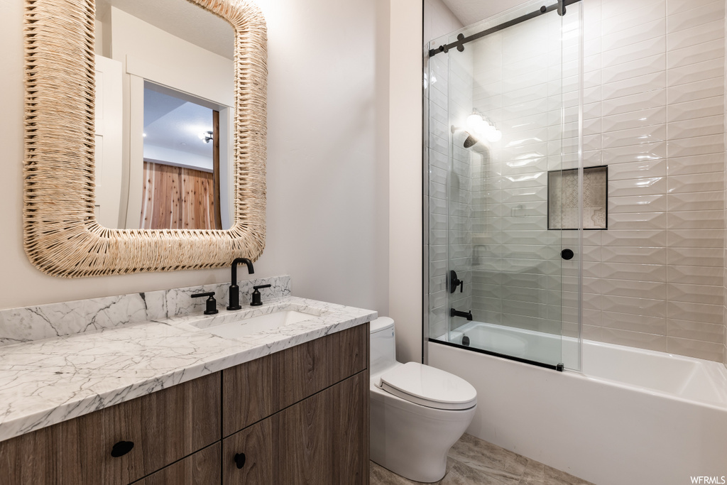full bathroom with tile flooring, mirror, vanity, shower / bath combination with glass door, and toilet