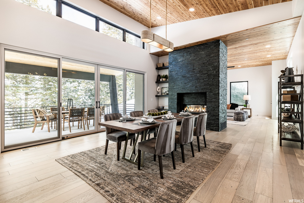 dining area featuring natural light, hardwood flooring, and a fireplace