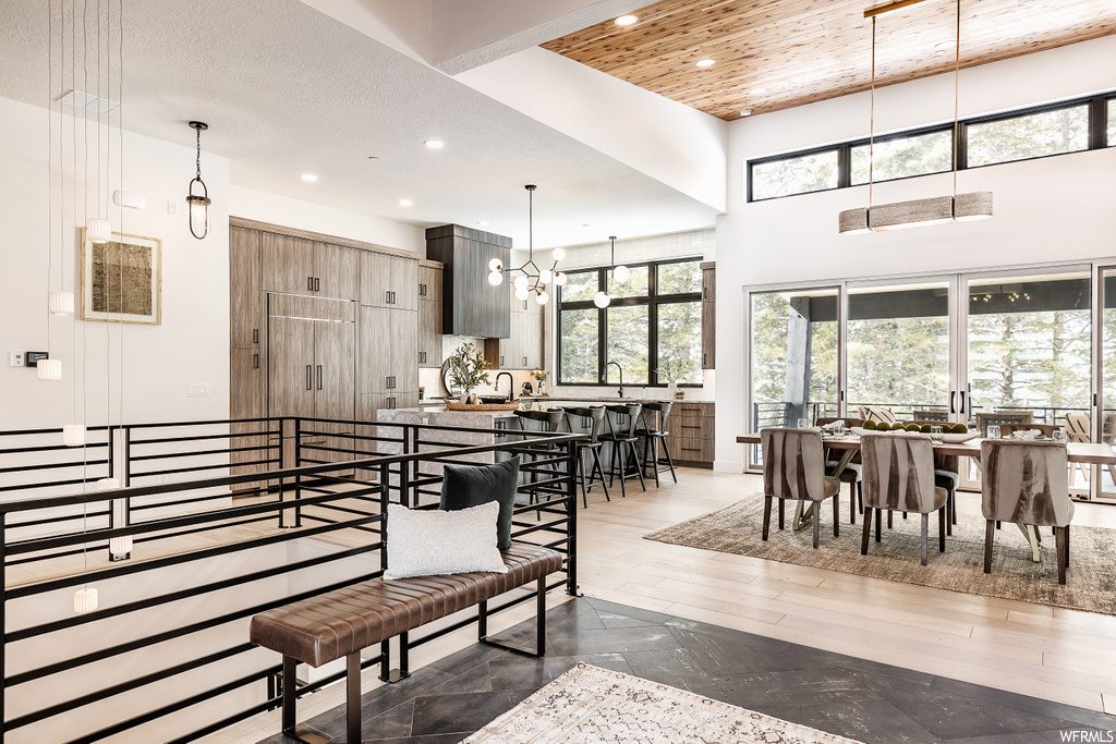wood floored dining area with natural light and a kitchen bar