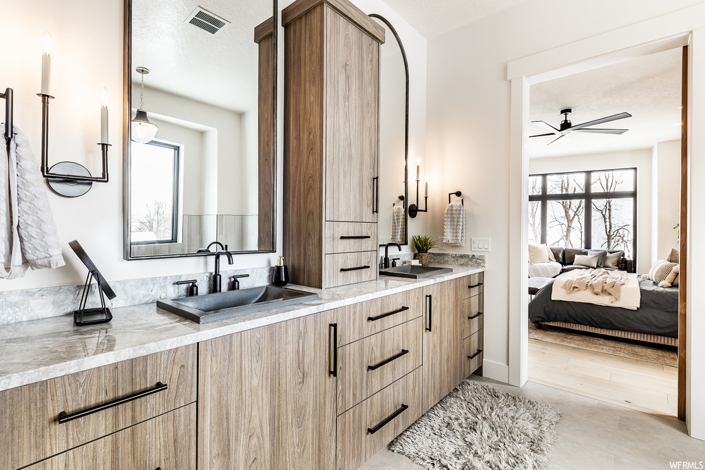 bathroom with hardwood floors, a healthy amount of sunlight, his and hers vanities, and mirror