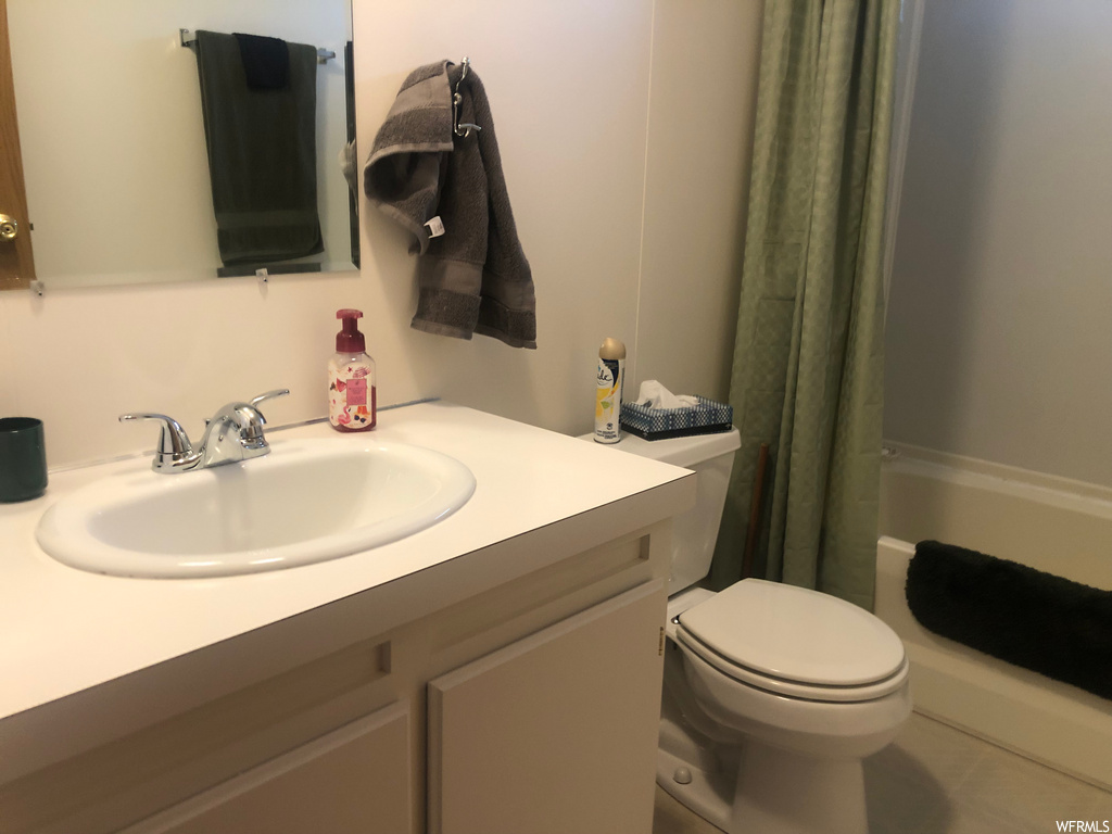 full bathroom featuring toilet, washtub / shower combination, shower curtain, mirror, and oversized vanity