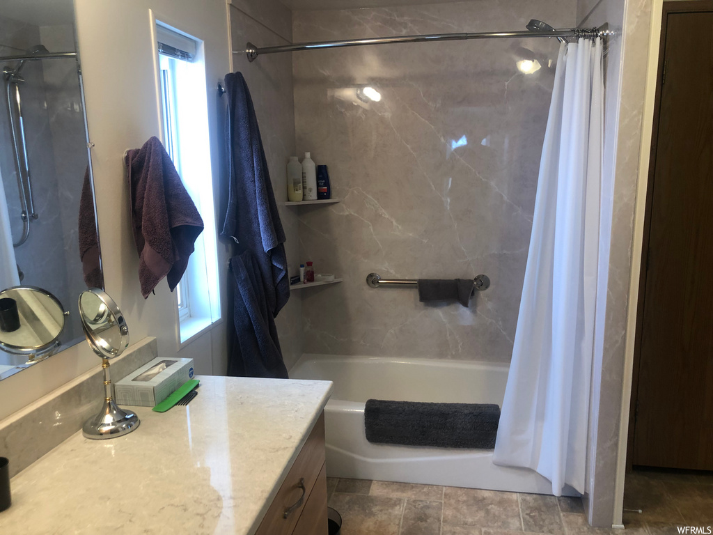 bathroom with natural light, tile flooring, shower curtain, shower / bathing tub combination, vanity, and mirror