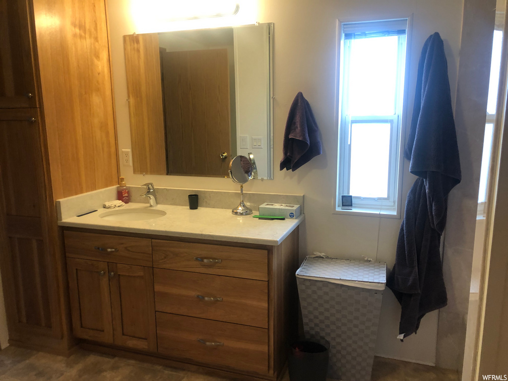bathroom with natural light, vanity, and mirror