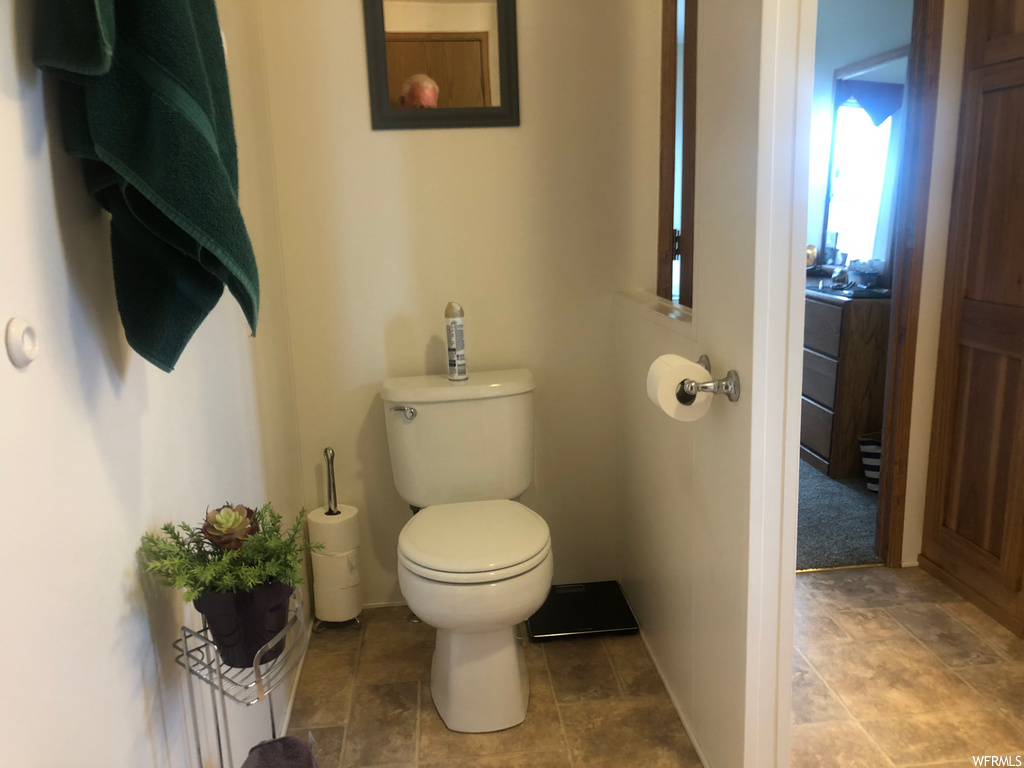 bathroom featuring tile flooring and toilet