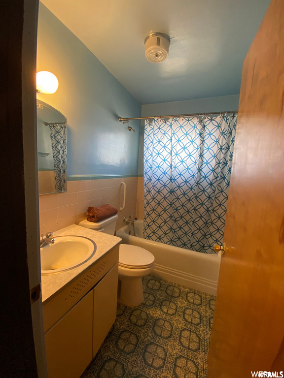 full bathroom featuring toilet, shower / bathing tub combination, large vanity, mirror, and shower curtain