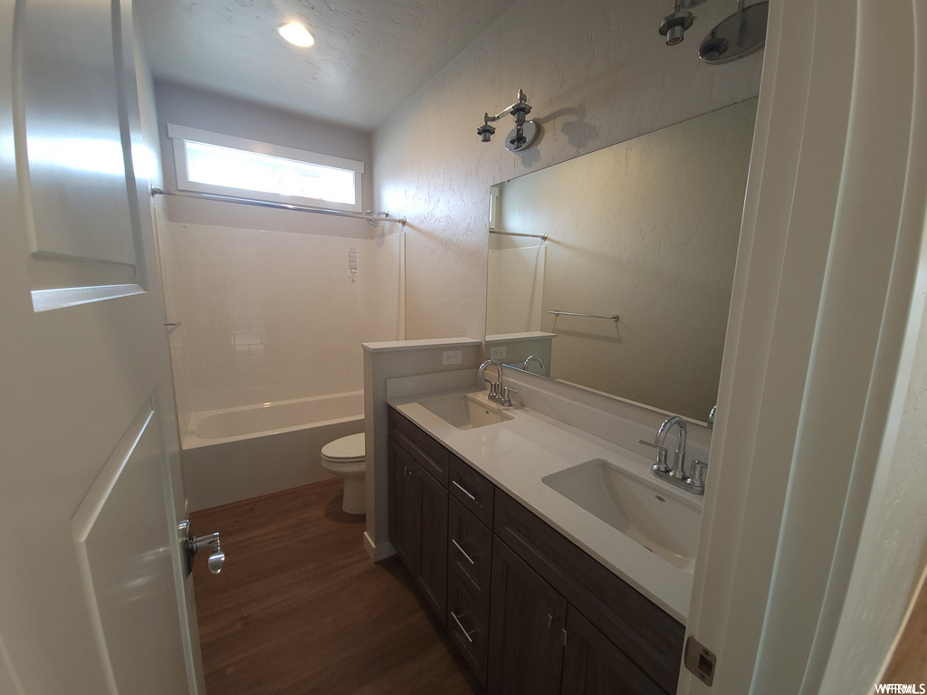 Full bathroom featuring washtub / shower combination, double large sink vanity, mirror, and toilet