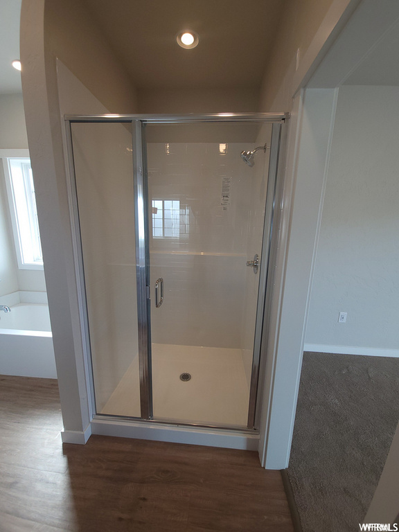 Bathroom with hardwood flooring and separate shower and tub