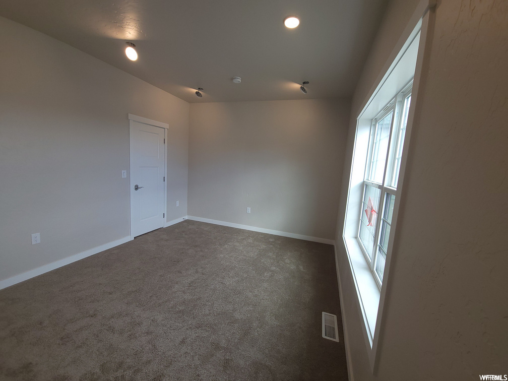Empty room featuring carpet and natural light