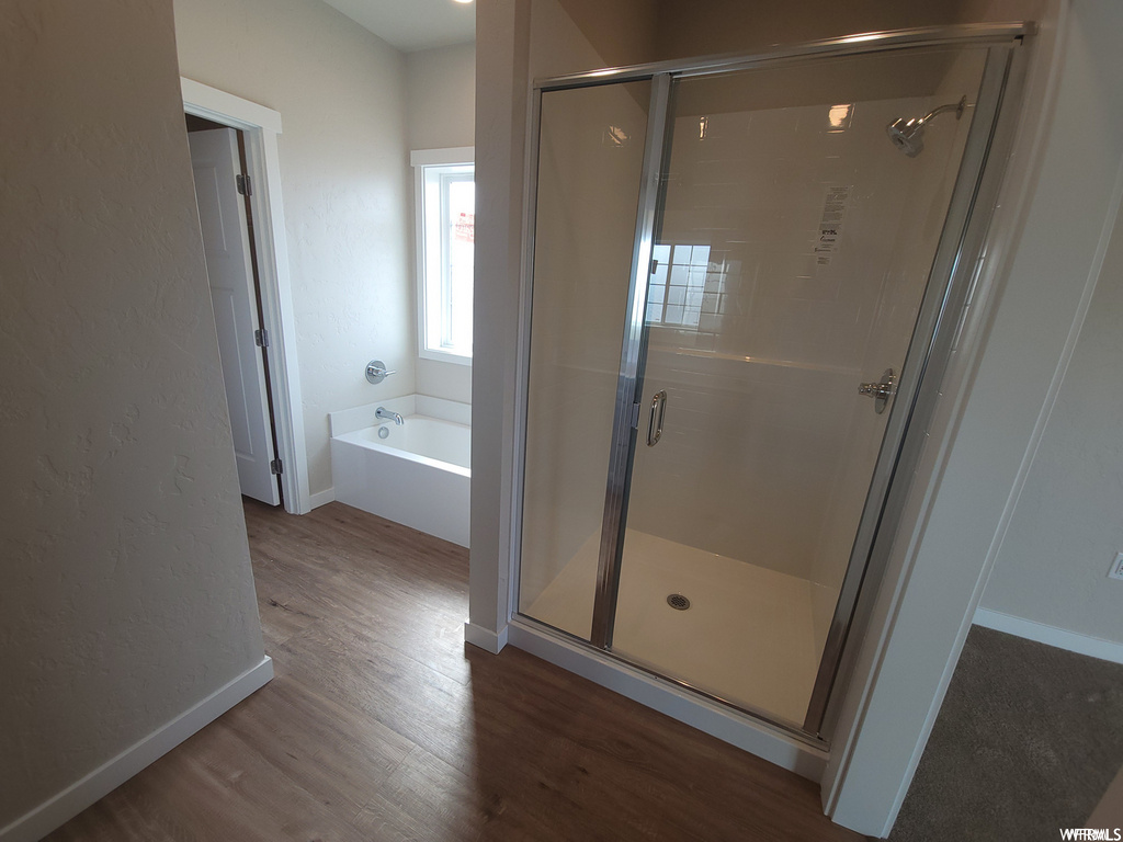 Bathroom featuring hardwood flooring and independent shower and bath