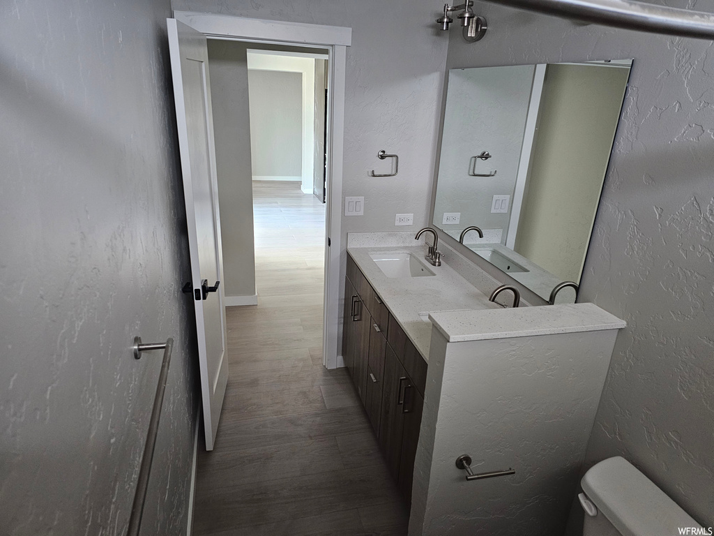 Bathroom featuring oversized vanity, mirror, and dark hardwood flooring