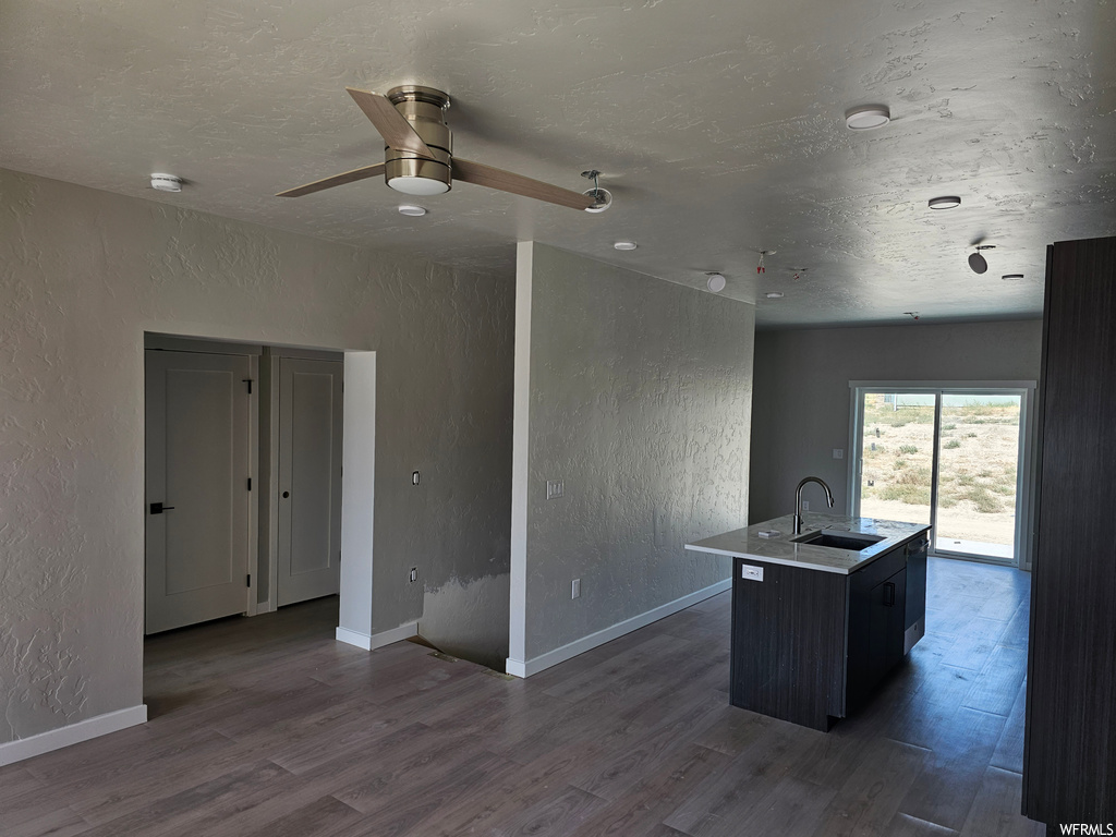 Kitchen featuring ceiling fan and dark hardwood flooring